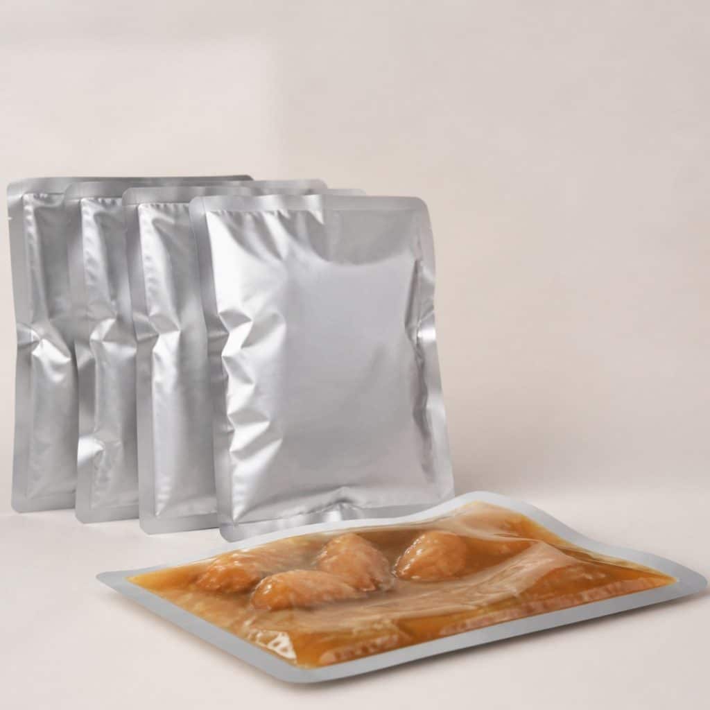 Sachets de pâtée en sauce posés sur fond neutre élégant